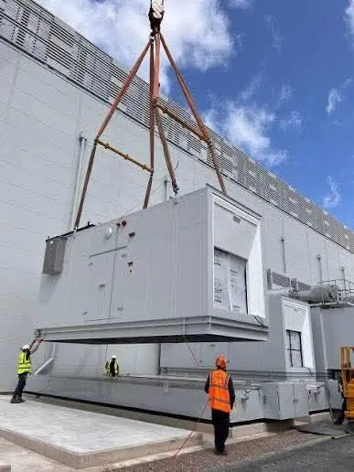 A crane rigging heavy electrical equipment